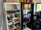 a room with a table, shelves, and a chair in it
