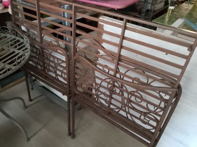 a metal bench with a pink cushion on top of it