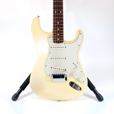 fender stratocator electric guitar on stand against a white background
