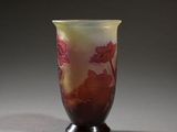a vase with a red flower on it on a table