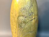 a yellow vase sitting on a table with a white background