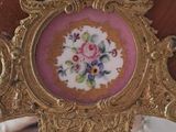 a gold frame with a picture of flowers on it