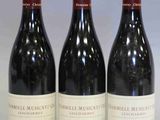 trois bouteilles de vin rouge sont alignées sur une table