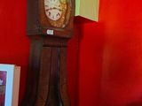 une horloge de parquet dans un coin d'une pièce aux murs rouges