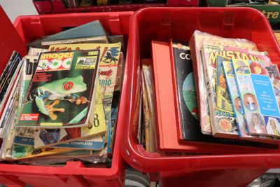 deux bacs rouges remplis de magazines et encore de magazines
