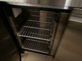 a metal counter with a metal shelf in the middle of it