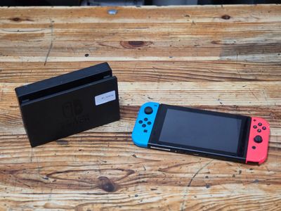 two nintendo wii controllers sitting next to each other on a wooden table