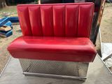 a red seat that is sitting on a metal bench