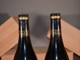 two bottles of wine sitting on a table next to each other