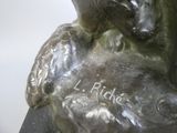 a bronze statue of a dog with a name on it
