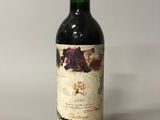 an old bottle of wine sitting on top of a white table