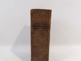 an old book sitting on top of a white table next to a white wall