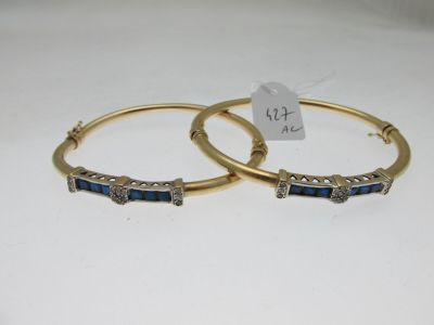 une paire de bracelets ornés de pierres bleues et de diamants