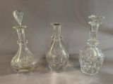 three clear glass bottles sitting next to each other on a table