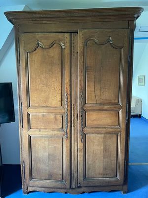 a large wooden armoire in the corner of a room