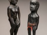deux sculptures représentant un homme et une femme debout l'un à côté de l'autre