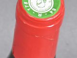 a close up of a bottle of wine with a red cap