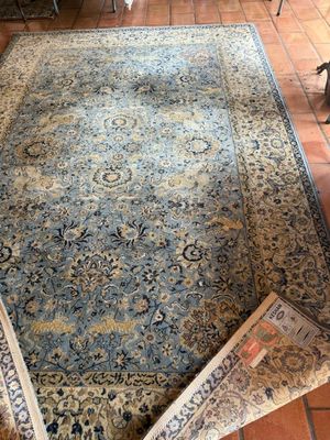 un tapis posé sur le sol d'un salon où se trouvent un fauteuil et une table