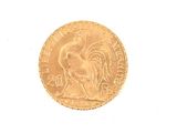 a gold coin with a rooster on it on a white surface
