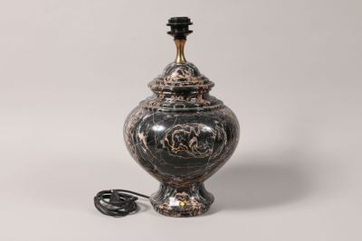 a black and gold vase sitting on a white surface