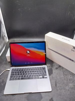 un ordinateur portable posé sur une table à côté d'une boîte