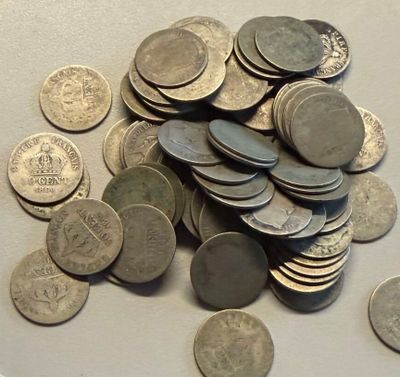 a pile of coins sitting on a table next to a cell phone