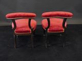a pair of red velvet upholstered chairs