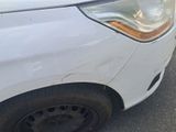 a white car that has a dent in the front of it