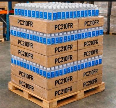 Des cartons d'eau sont empilés sur une palette dans un entrepôt