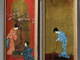 two framed paintings of women in kimono outfits are on display