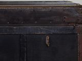 a black trunk sitting on top of a wooden table