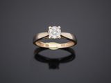 a single stone diamond ring on a black surface