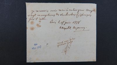 un vieux morceau de papier avec une écriture dessus, posé sur une table
