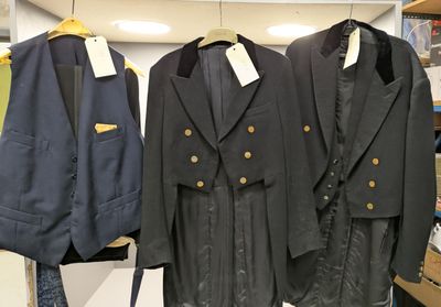 trois vestes suspendues à un portant dans un magasin