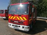 two fire trucks parked next to each other in the dirt