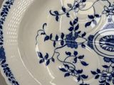 a blue and white plate with a flower design on it