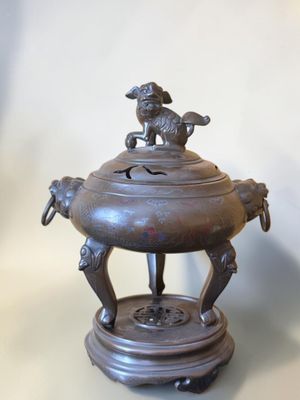 an antique bronze incense burner with a bird on top of it