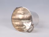 a silver cup with a chain around it on a white surface