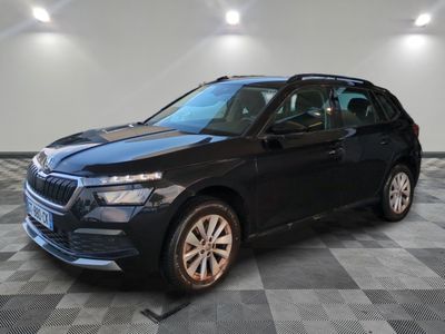une voiture noire est garée dans une pièce au sol en damier