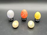 four different colored marble balls sit on top of a black surface