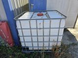 a large white container sitting on the ground next to a blue building