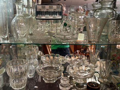 a glass display case filled with glass vases and glasses
