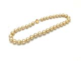 gros plan d'un collier de perles sur une surface blanche