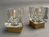 pair of clear glass candle holders with gold bases on a gray surface