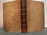an old book sitting on top of a table next to a wall