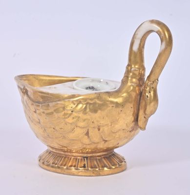 un vase doré orné d'une anse en forme de cygne sur fond blanc