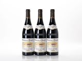 trois bouteilles de vin posées les unes à côté des autres sur une surface blanche