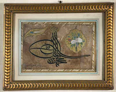 painting of arabic calligraphy in gold frame on wall