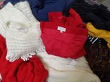 a pile of clothes that is sitting on a bed