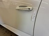 a door handle on a white car with a sticker on it